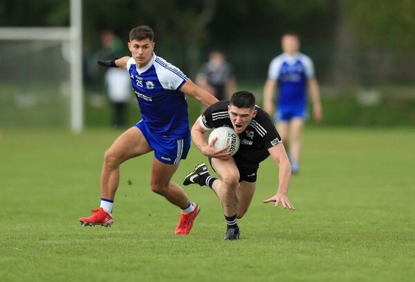 Éire Óg centre-forward Jason Doory falls to the Orchard Park turf under pressure from St. Croan's defender Cathal Connelly during Sunday's quarter-final in Elphin. 