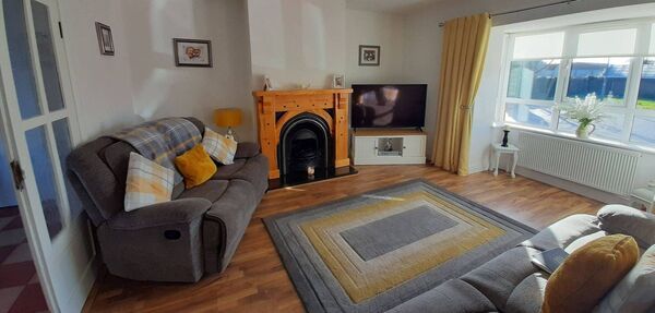 The sitting room has an open fireplace.
