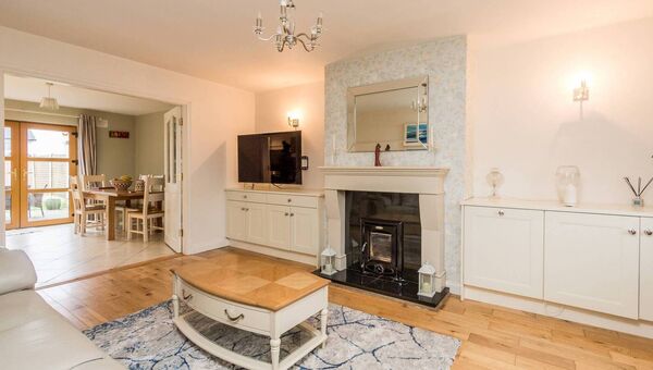 The living has wood flooring and a stove fireplace.