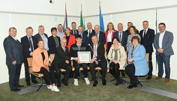 Cormac Rynn is presented with a Dermot Earley Bursary by the Chief Executive of Roscommon County Council Shane Tiernan and Leas Cathaoirleach Cllr John Cummins. Also pictured are family members, members and executive of Roscommon County Council. Pic. Gerard O'Loughlin