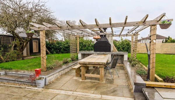 The property has a large garden with patio and barbecue area to the rear. 