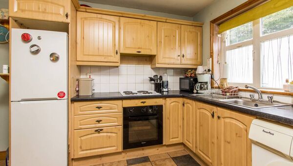 The kitchen/dining room has fully fitted units and tiled flooring.