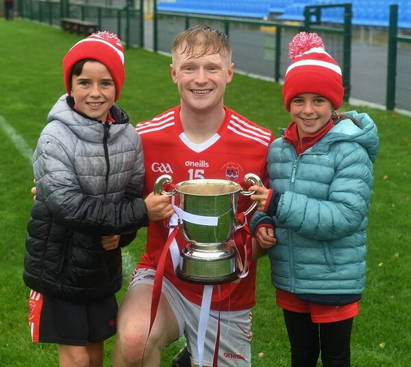 Pádraig Pearses forward Paul Carey alongside Evan and Lucy Flynn celebrate with the Fahey Cup following their side's county final triumph.