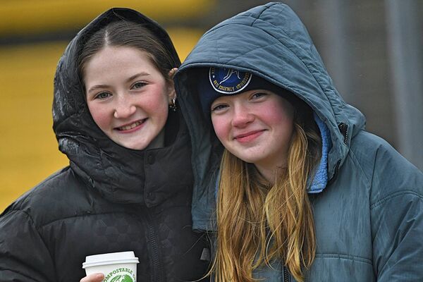 SINGING IN THE RAIN: Méabh Mannion and Emma Hughes supporting the Roscommon senior footballers in the wind and rain at King and Moffatt Dr. Hyde Park on Sunday last. 