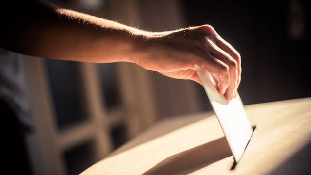 <p>Conceptual image of a person voting, casting a ballot at a polling station, during elections.</p>