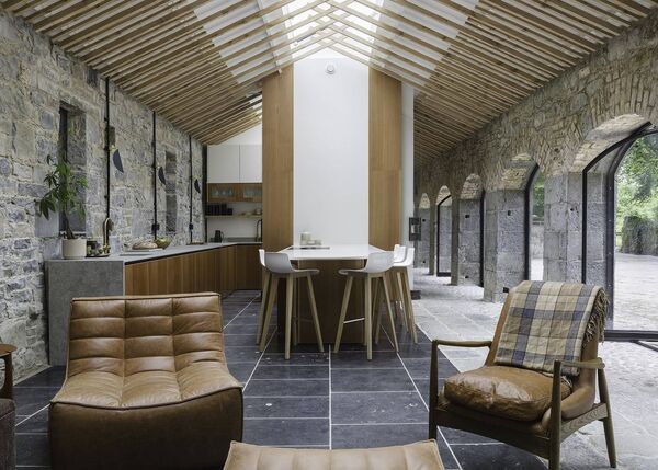 The beautiful interior of the former cowshed at Rockingham with wood from the nearby forest featuring in the ceiling and kitchen design.