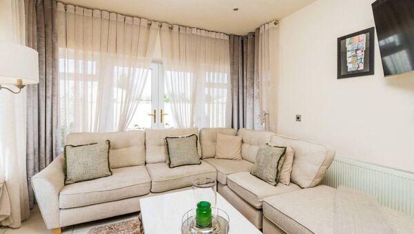 The living room features double doors leading to the garden.