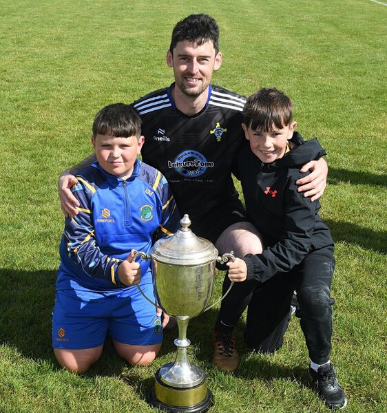 St. John's Athletic goalkeeper, Seán Coyle, with his nephew Eoin Moore and Luke Martin following their side's Challenge Cup final triumph. St. John's Athletic goalkeeper, Seán Coyle, with his nephew Eoin Moore and Luke Martin following their side's Challenge Cup final triumph.