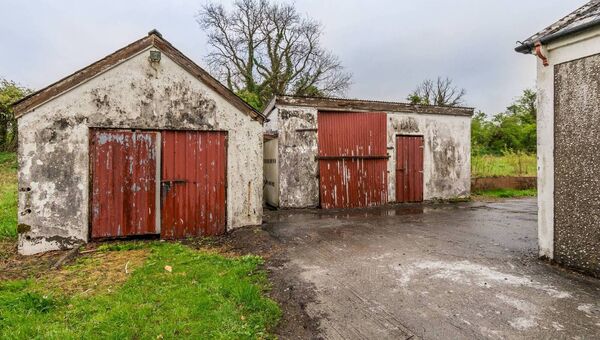 The outdoor space includes a large garage and rear shed (both wired for lighting), as well as a smaller garden shed.