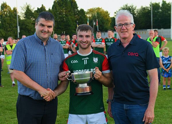 Winning St. Brigid's captain Paul McGrath is presented with the O’Rourke Cup by Roscommon GAA Chairperson, Brian Carroll, and Philip Martin, Cora Systems, Division One Football League sponsor. Picture: Gerard O’Loughlin