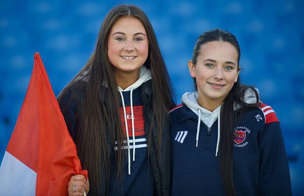 Caoimhe O’Byrne and Lily Hogarty supporting the Pádraig Pearses senior footballers during Saturday's county final replay against St. Brigid's at King and Moffatt Dr. Hyde Park. 