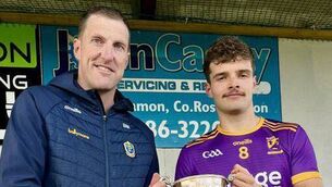 <p>Roscommon Gaels U-20 football captain, Rory Carthy, accepts the cup from Roscommon GAA Secretary, Brian Mullin, following his side's U-20 Division One final victory against Michael Glaveys/Éire Óg at Rockfield. Picture: Roscommon GAA</p>