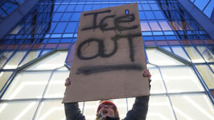<p>A demonstrator holds a sign reading "ICE OUT" during a protest in Minneapolis. Pic: AP Photo/Adam Gray)</p>