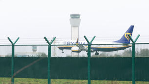 <p>A Ryanair plane lands in front of the control tower at Dublin Airport. </p>