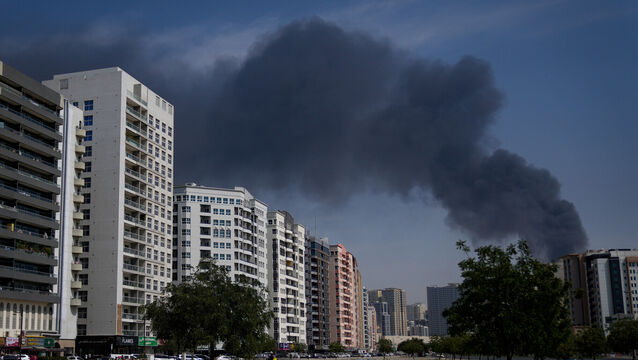 <p>A cyclist rides past as black plume of smoke is seen rising from a warehouse at the industrial area of Sharjah City in the United Arab Emirates. Pic: AP Photo/Altaf Qadri)</p>