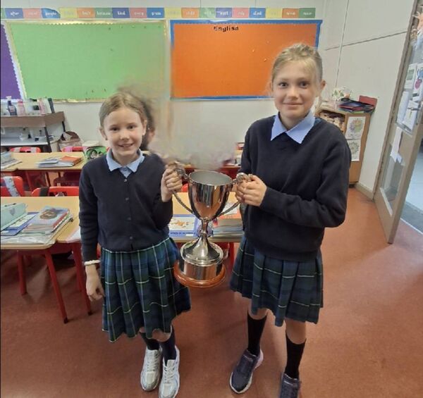 Students from St. Anne’s NS, Castlerea with the Castlerea Celtic silverware won recently by the club.