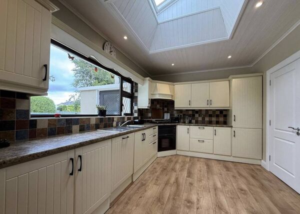The fully fitted kitchen/diner has a stove and double doors opening onto the garden.