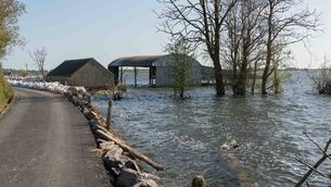 <p>Flooded sheds with a barrier protecting the newly tarred road at Lough Funshinagh back in April of 2024. Pic: Gerry Faughnan</p> <p>Flooded sheds with a barrier protecting the newly tarred road at Lough Funshinagh back in April of 2024. Pic: Gerry Faughnan</p>